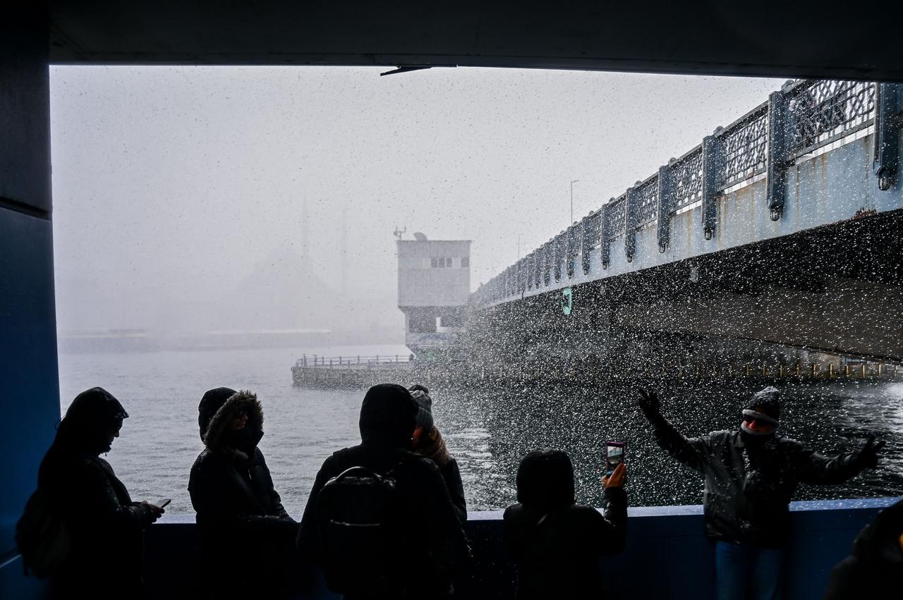 People spend time outside as snowfall continues in Karakoy district of Istanbul, Türkiye, Jan. 1, 2026. (AA Photo)