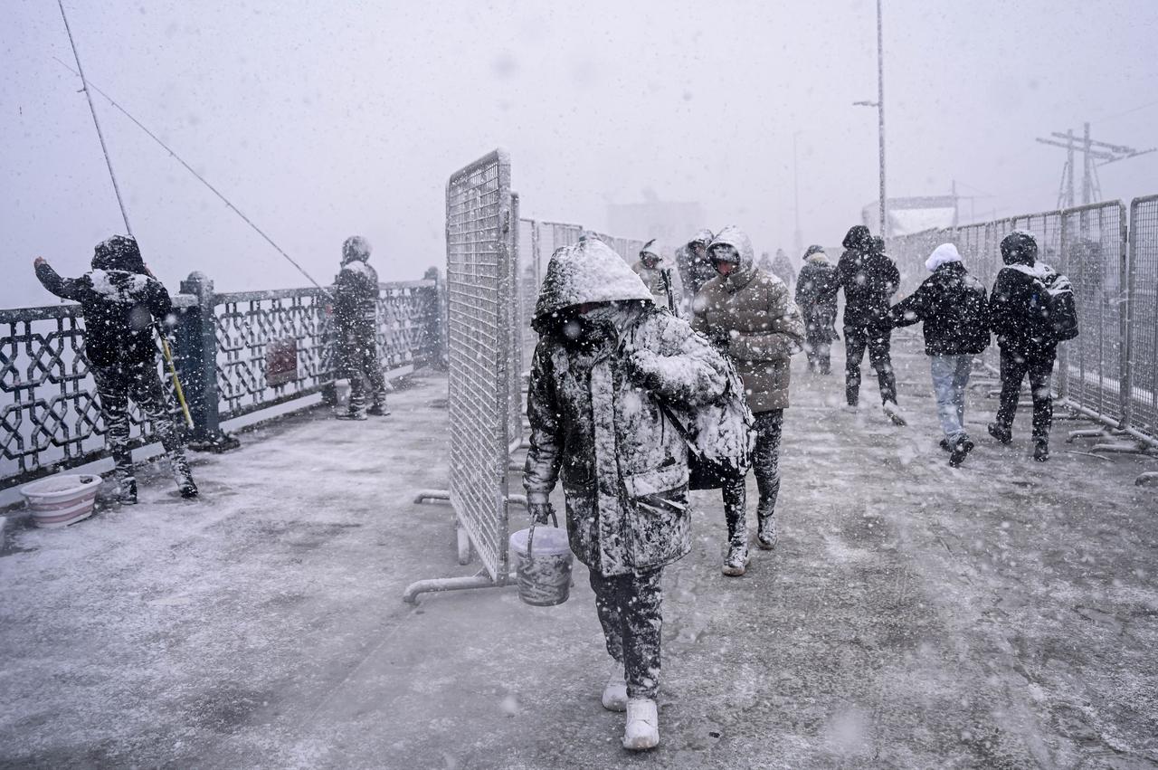 People spend time outside as snowfall continues in Karakoy district of Istanbul, Türkiye, Jan. 1, 2026. (AA Photo)