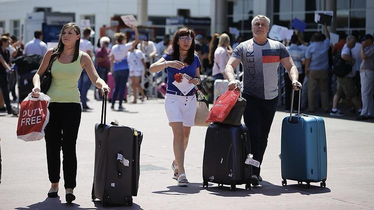 Tourists exit an airport terminal with suitcases, illustrating steady passenger flows and continued interest in Türkiye as a travel destination. (Photo via Ministry of Culture and Tourism)