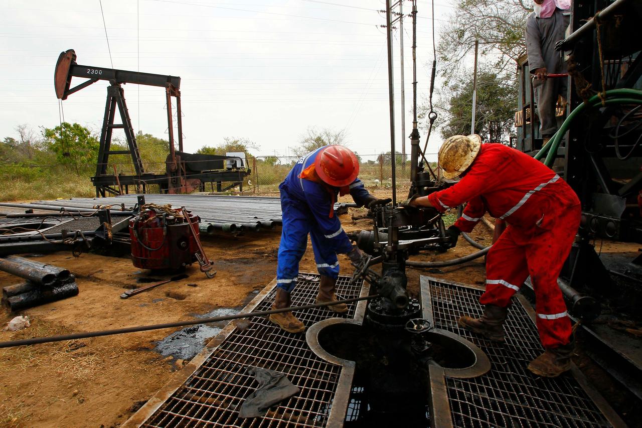 Oil workers operate drilling equipment at an oil field in Venezuela. (Adobe Stock Photo)