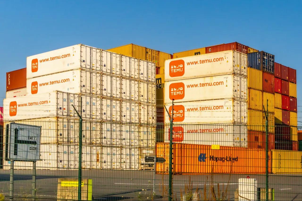 Stacked shipping containers belonging to Chinese e-commerce platform Temu at a port in Belgium. (Adobe Stock Photo)