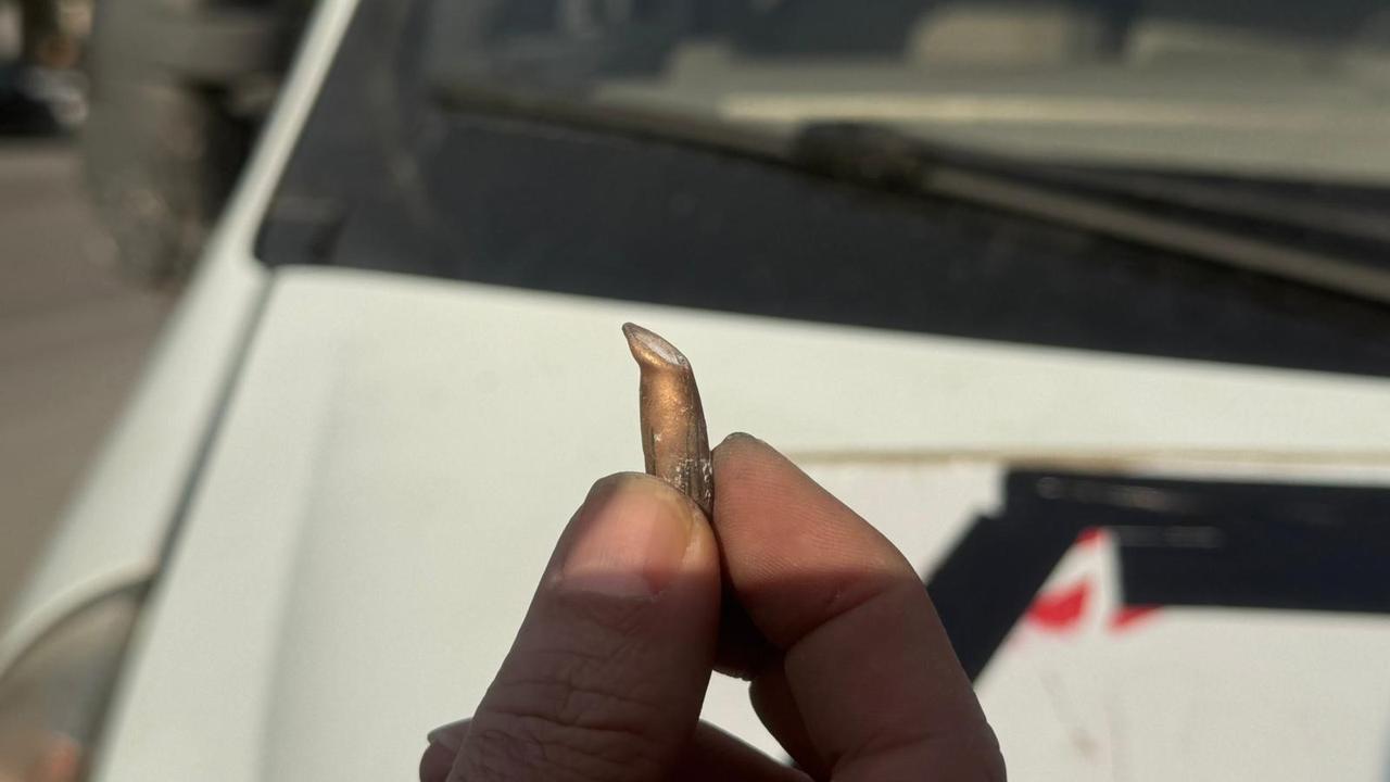A round is being inspected by a person after the SDF targeted a Turkish news agency's vehicle in Aleppo, Syria. (IHA Photo)
