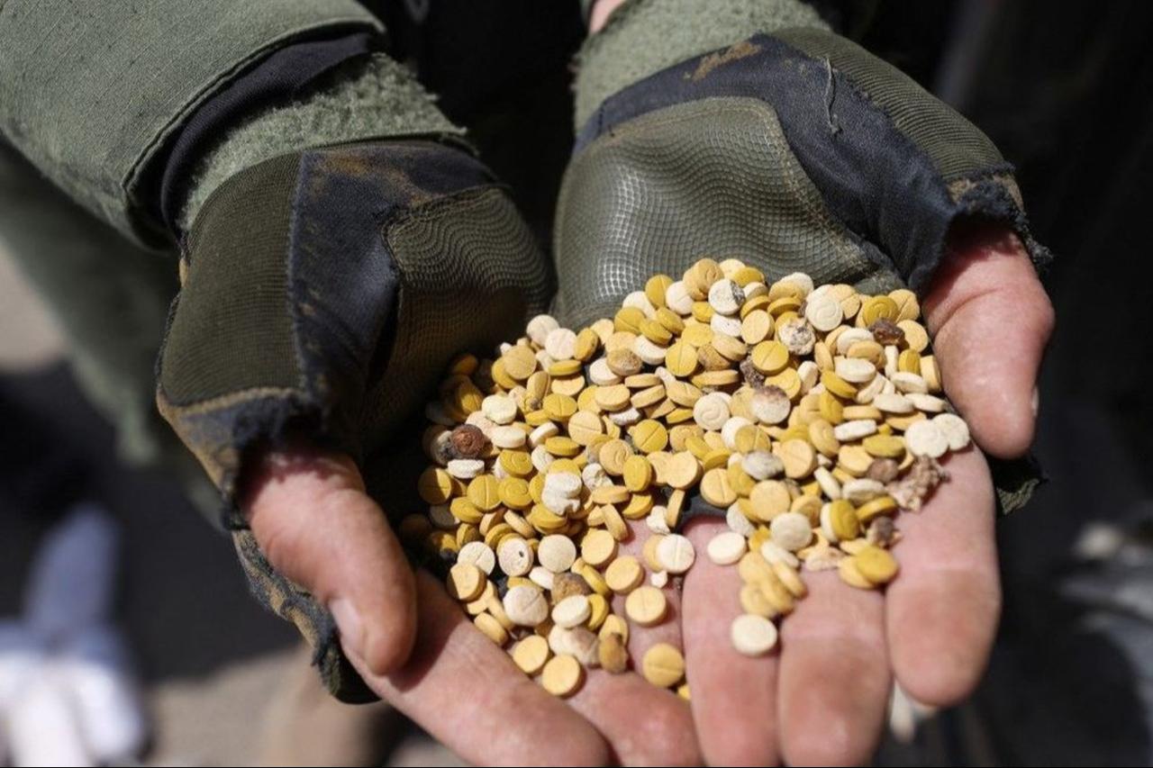 Fighters affiliated with Syrias Hayat Tahrir al-Sham (HTS) rebel group display drugs previously seized at a checkpoint they control in Daret Ezza, Aleppo, Syria on April 10, 2022. (AFP Photo)