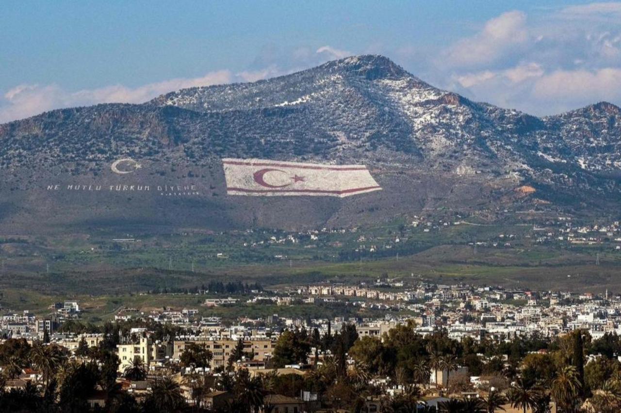 A view of snow covering a portion of Cyprus northern Girne mountain range, above the flag of the Turkish Cyprus (TRNC), Lefkosia, March 13, 2022. (AFP Photo)