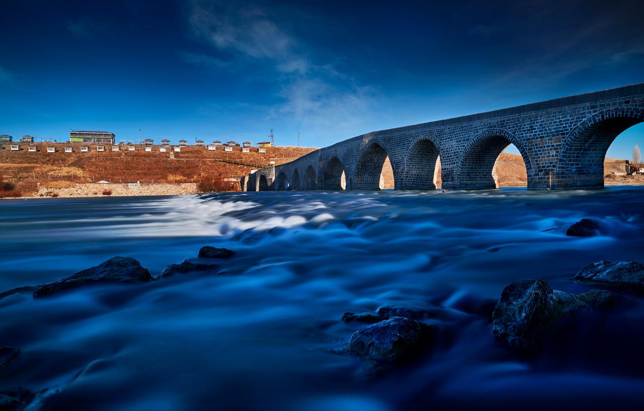 A historic stone bridge spans a fast flowing river in Mus province as winter sun reflects off the water in eastern Türkiye, accessed on January 9, 2025. (Adobe Stock Photo)
