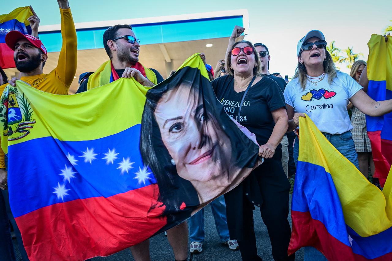 People hold a Venezuelan flag with a picture of opposition leader, Nobel peace laureate Maria Corina Machado, in Doral, Florida, near Miami, Jan. 3, 2026. (AFP Photo)