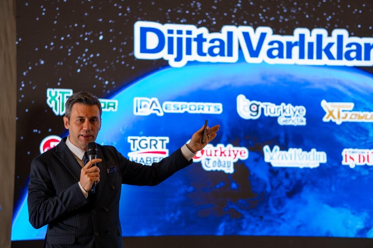 Volkan Ormanli speaking at a Digital Assets presentation event, pointing to a screen displaying digital media and esports brands under Ihlas Media Group, Türkiye. (IHA Photo)