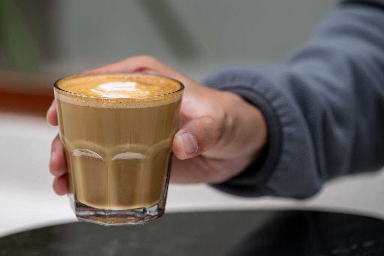 A person holds a glass of milk-based coffee on World Coffee Day, Oct. 1, 2026. (AA Photo)