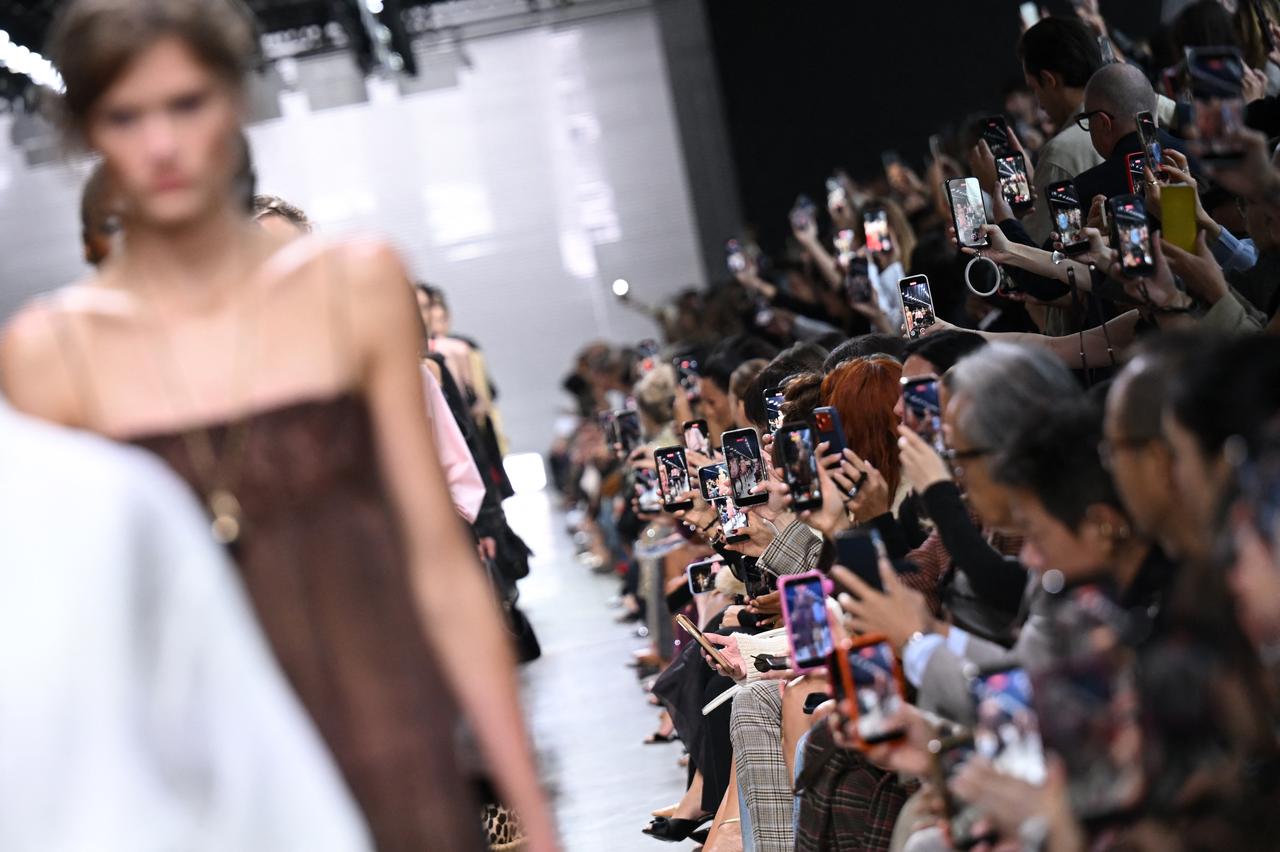 Audience members record a runway show on their smartphones during Milan Fashion Week in Milan, Italy, Sept. 26, 2026. (AFP Photo)
