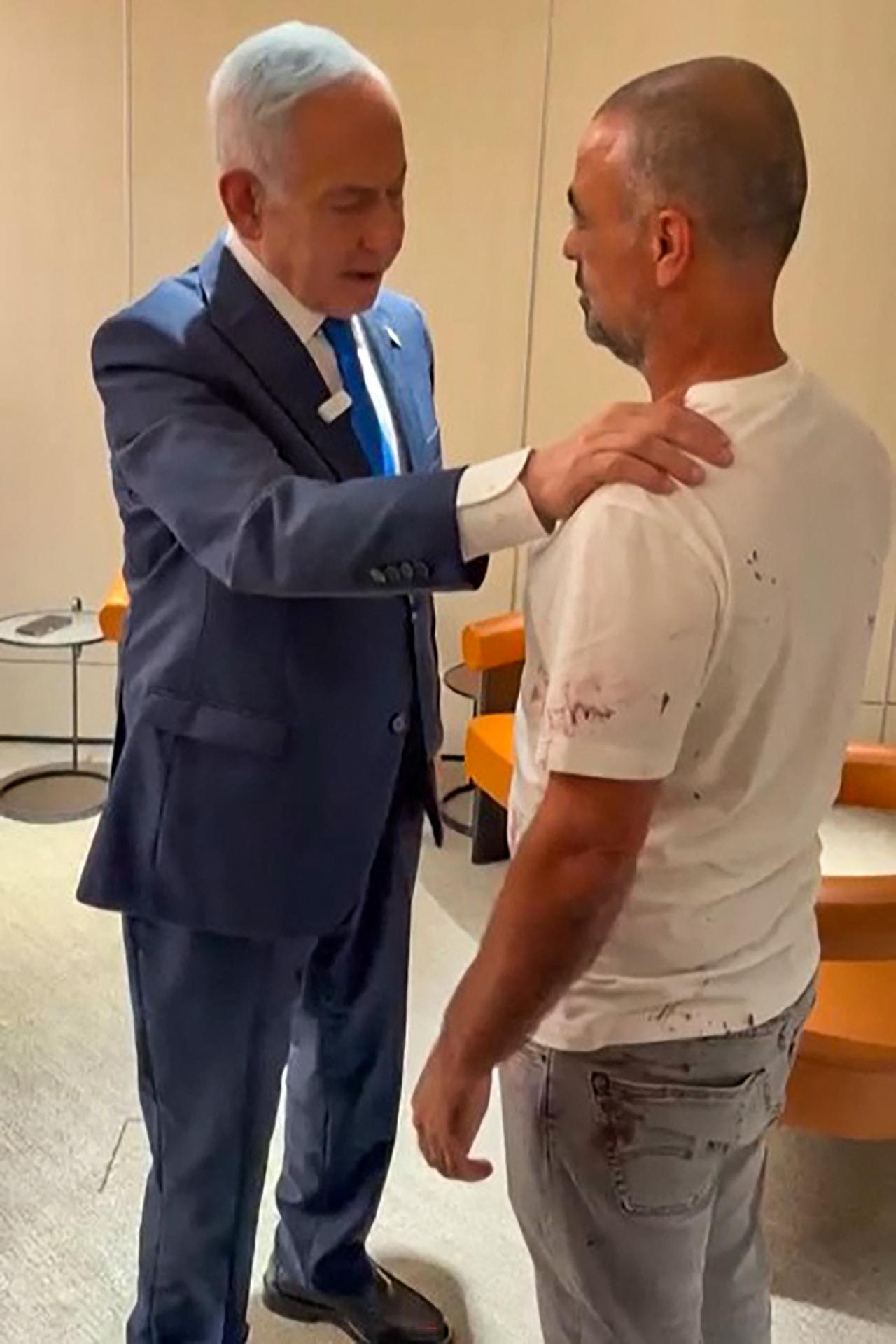 This screen grab taken from video footage shows Israel's Prime Minister Benjamin Netanyahu (L) meeting a man named Yaniv, describing him as one of the passengers who managed to break into the flydubai aircraft's cockpit, at Israel's Ben Gurion Airport in Lod, Sept. 30, 2026. (AFP Photo/Israeli Prime Minister's Office/Handout)