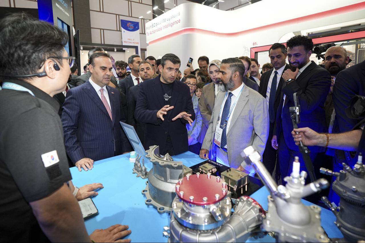 Turkish Minister of Industry and Technology Mehmet Fatih Kacir and Selcuk Bayraktar, Chairman of the Board of Trustees of the T3 Foundation and Chairman of Baykar, tour the fairground during the 77th International Astronautical Congress (IAC) in Antalya, Türkiye, Oct. 9, 2026. (AA Photo)