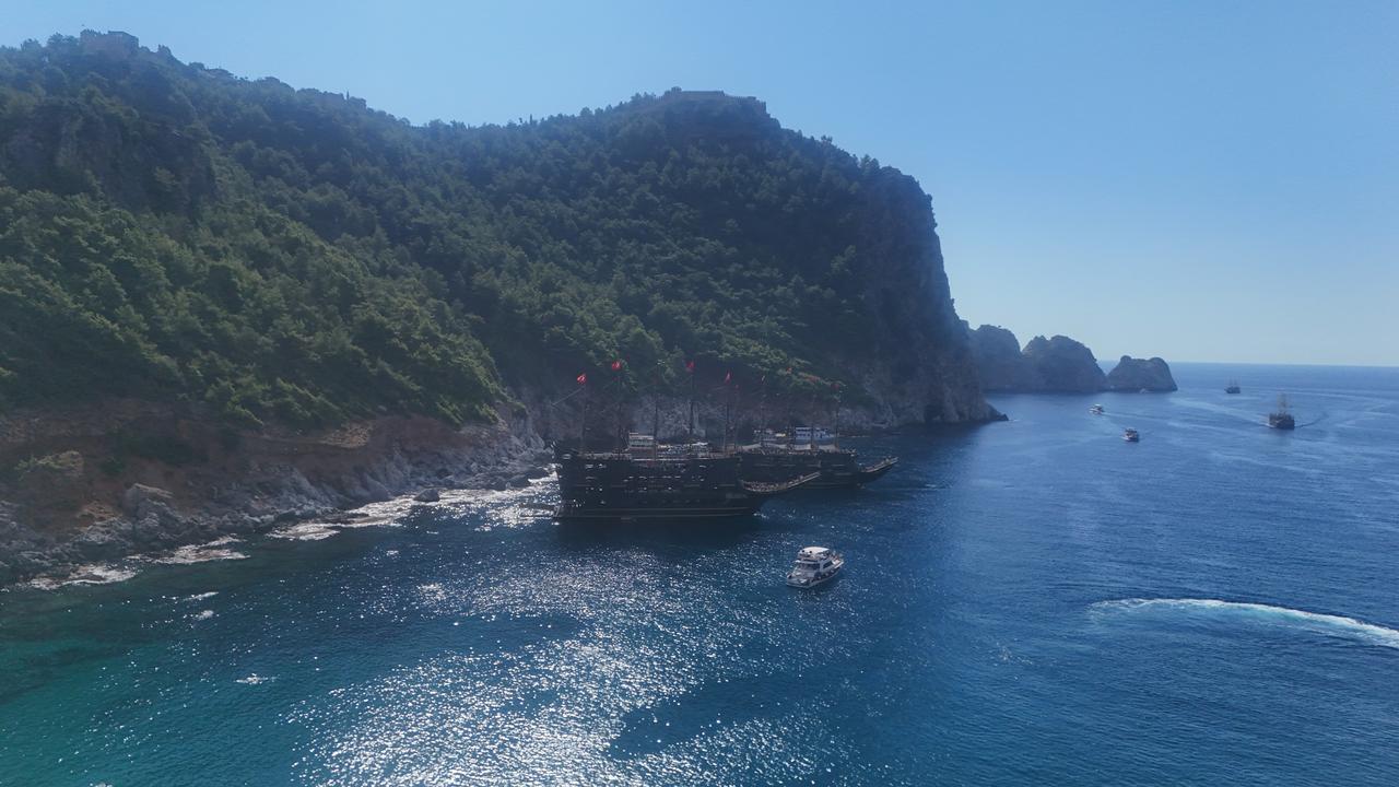 Tour boats sail along Alanya's rocky coastline in Antalya as sunny weather keeps tourism activities going well into October, Türkiye, Oct. 8, 2026. (IHA Photo)
