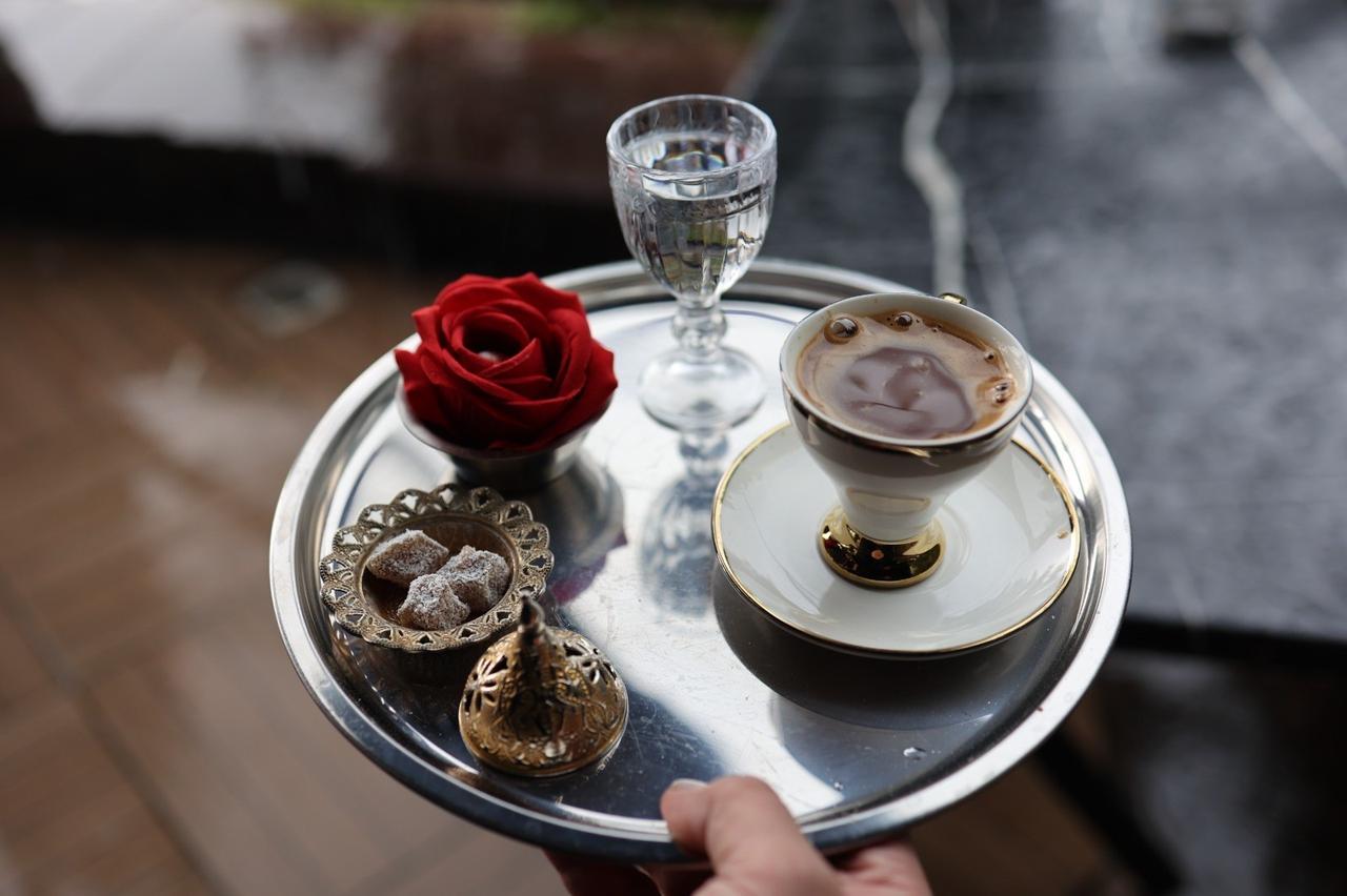 Turkish coffee brewed in heated rock salt is served alongside water, Turkish delight and a decorative red rose in Cankiri, Türkiye, Oct. 10, 2026. (IHA Photo)