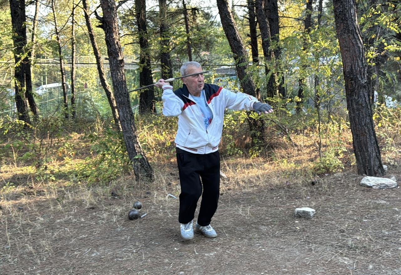 An 84-year-old athlete practices a throwing technique during an outdoor training session in Türkiye, Oct. 11, 2026. (AA Photo)