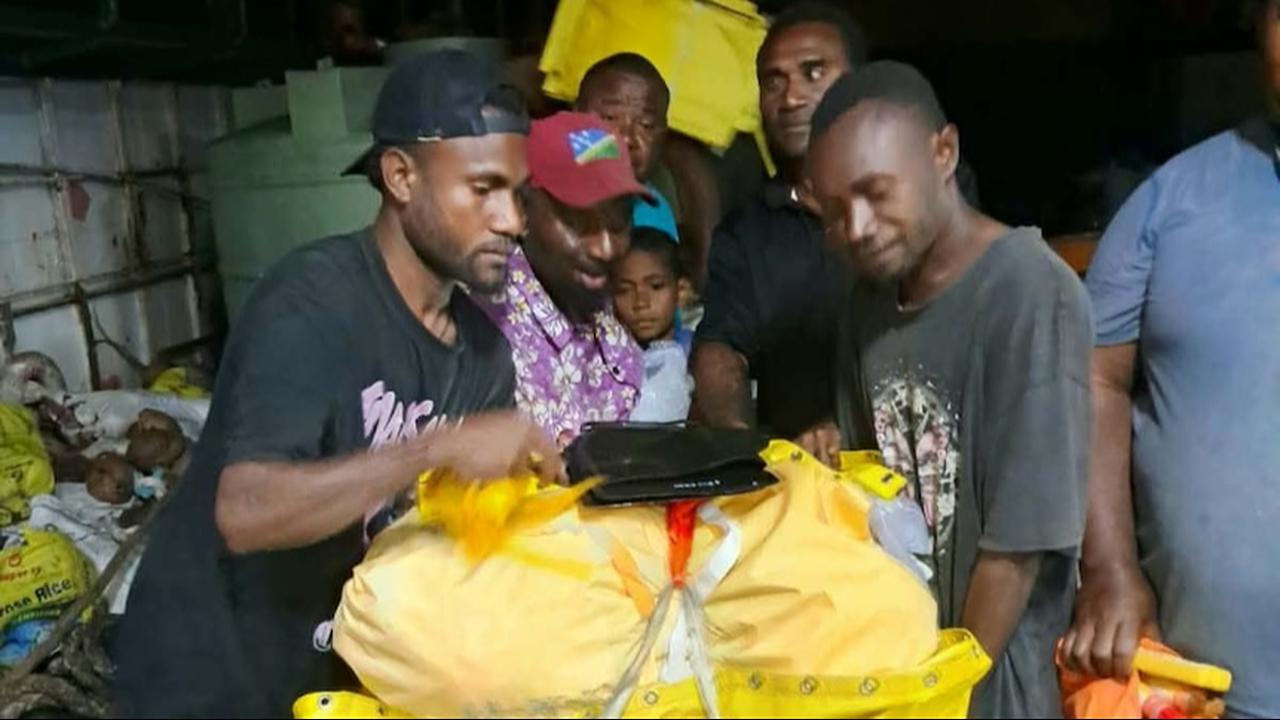 Passengers with a life raft retrieved from a French aircraft drop. (Photo via ABC)