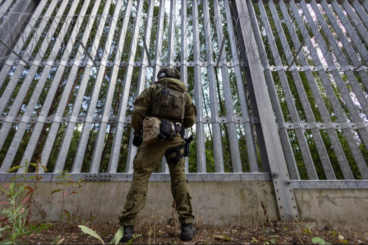 A Polish border guard officer stands at the Polish-Belarusian country border in front of the border fence in Polowce-Pieszczatka, Poland, on July 21, 2025. (AFP Photo)