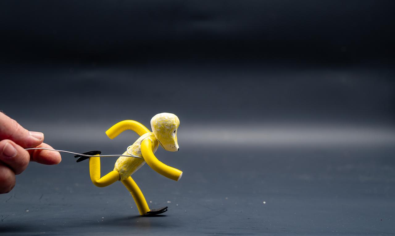 A stop-motion figure is manipulated by hand during the animation production process. (Adobe Stock Photo)