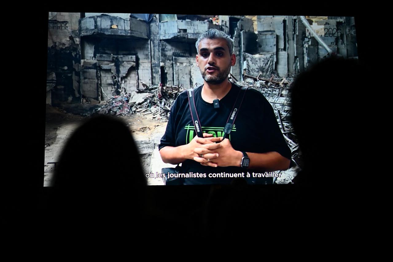 Palestinian photographer Mahmoud Abu Hamda delivers a pre-recorded speech displayed on a screen in France, on Oct. 10, 2026. (AFP Photo)