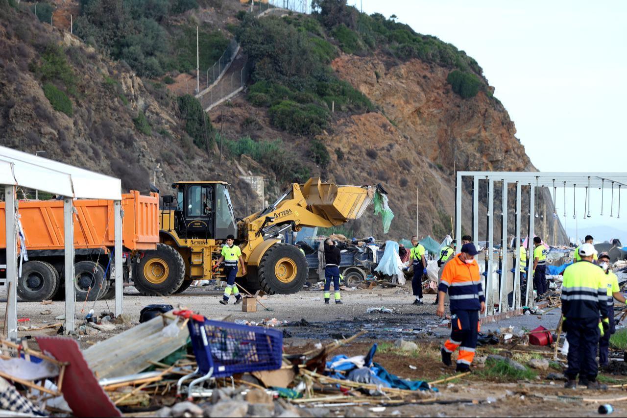 Workers clear debris after Spanish police removed migrants from temporary makeshift camp El Guano near the Trampolin beach in Spain's north African enclave of Ceuta on Oct. 11, 2026. (AFP Photo)