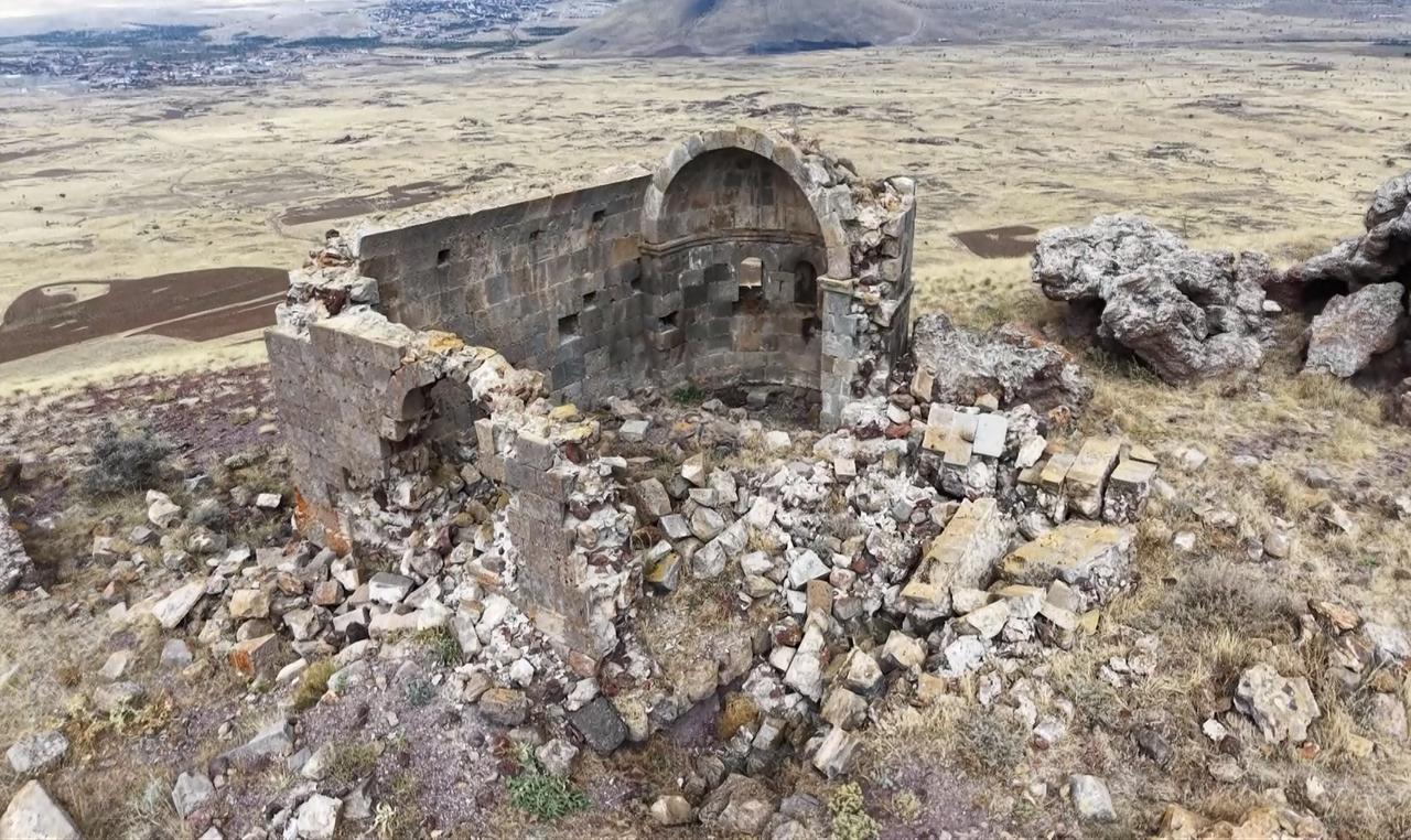 An aerial view shows the ruins of the 725-year-old church on Ana Sultan Hill, surrounded by rocky terrain and open fields in Aksaray, central Türkiye. (IHA Photo)