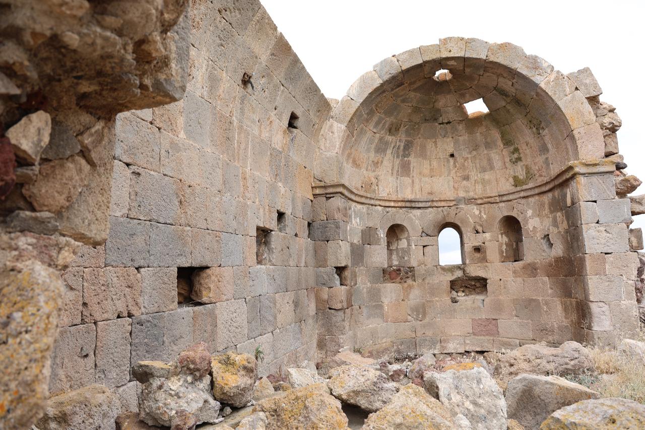 The interior of the historic church on Ana Sultan Hill reveals a partially preserved semicircular apse, arched openings and fallen stone blocks. (IHA Photo)
