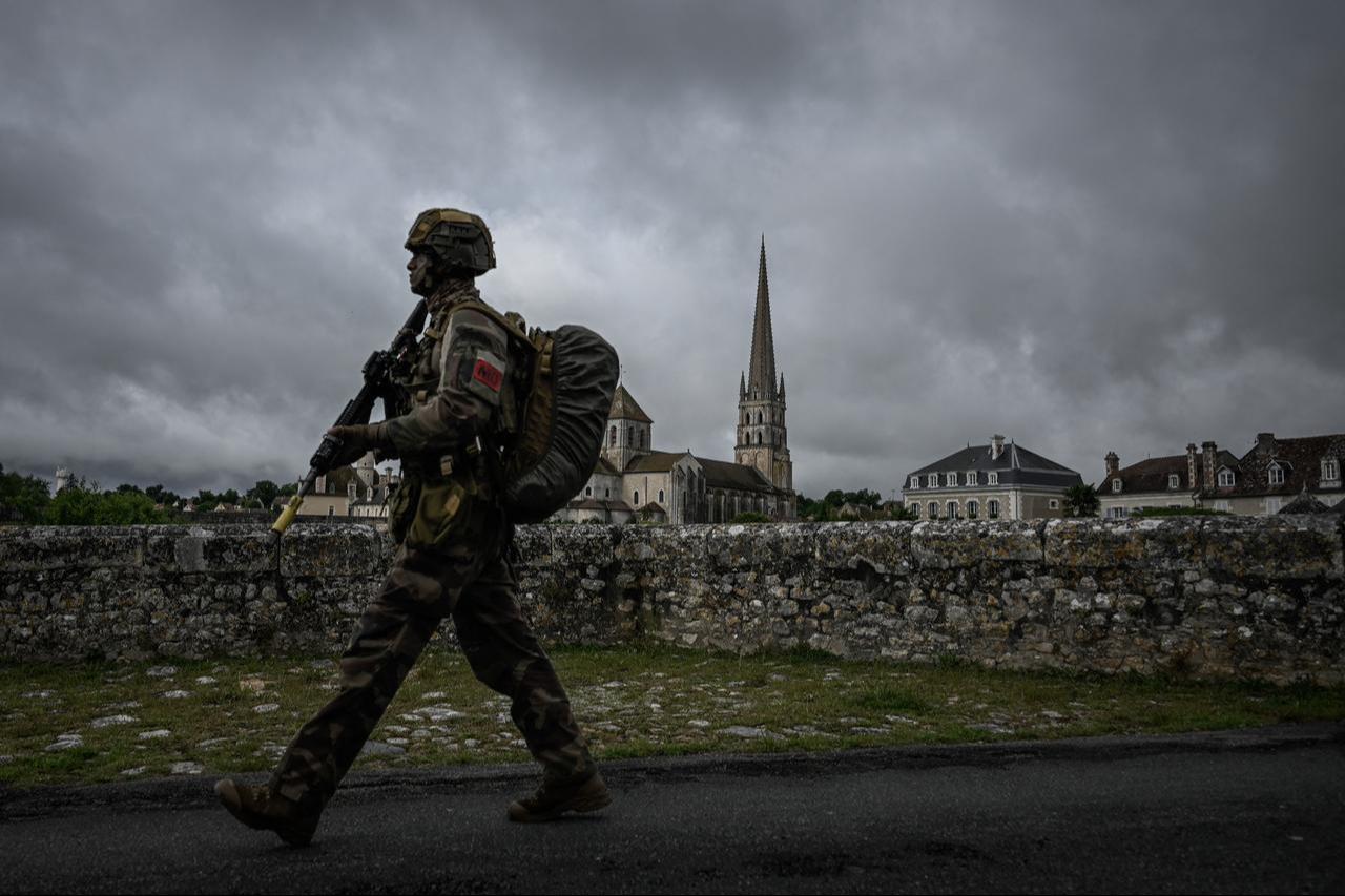 A French Foreign Legion paratrooper patrols a bridge over the Gartempe River with the abbey of Saint-Savin-sur-Gartempe in the background during a bridge defense exercise in Saint-Savin, southwestern France, May 17, 2026. (AFP Photo)