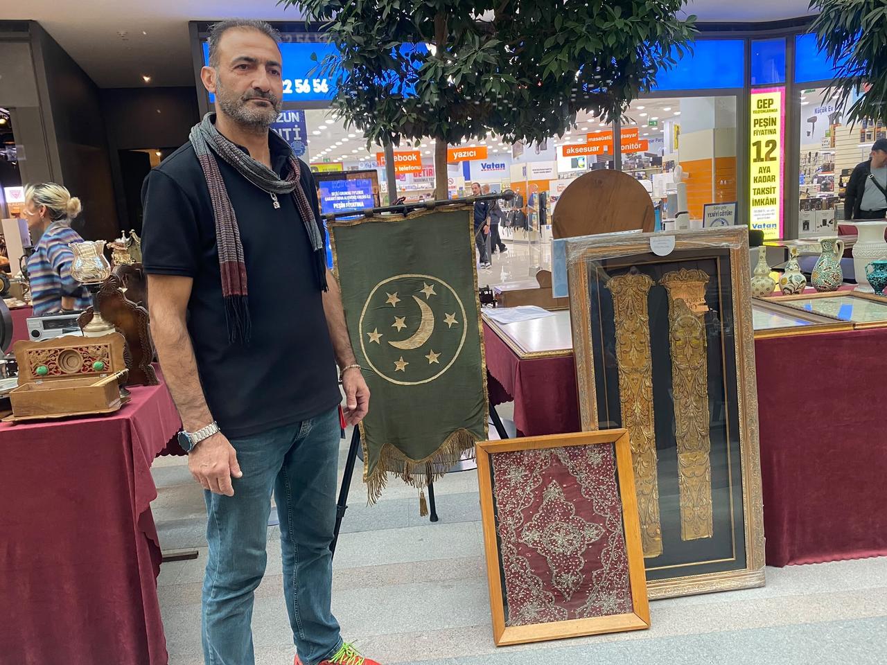 Antique collector Koksal Gulcemal displays a rare Ottoman velvet banner dating back to the 1890s at an antique fair in Ankara, Türkiye, Oct. 12, 2026. (IHA Photo)