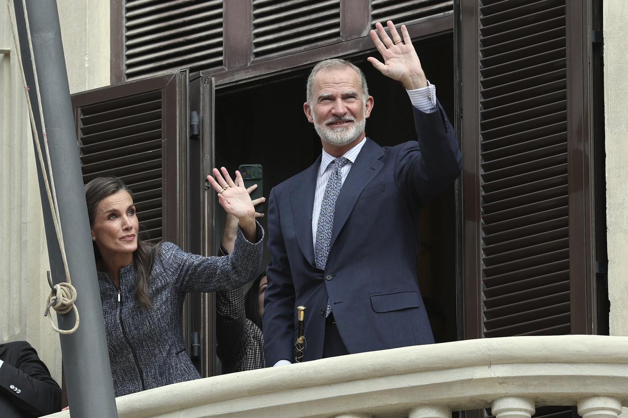 Spain's King Felipe VI (R) and Queen Letizia (L) wave from the City Hall balcony upon their arrival in the Spanish North African enclave of Ceuta, on Oct. 13, 2026. (AFP Photo)