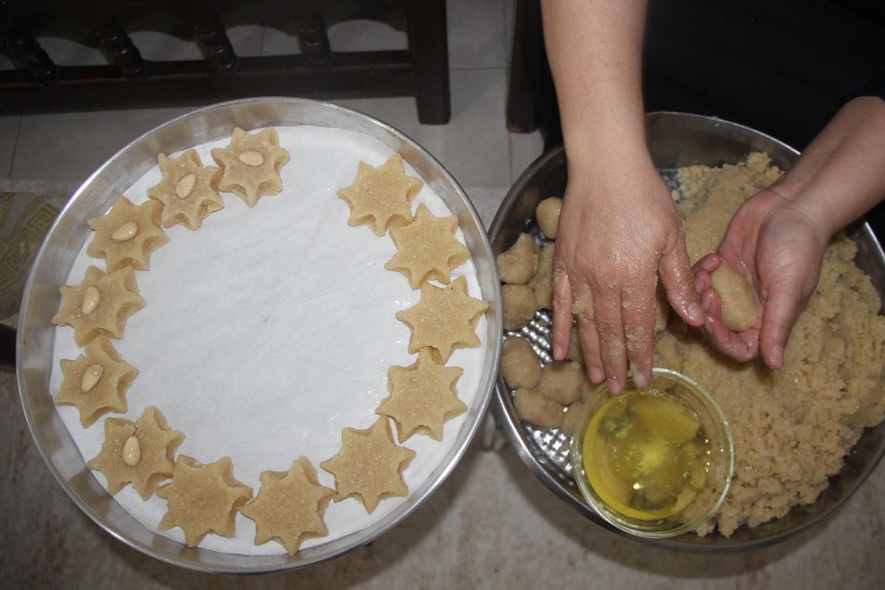 A local producer shapes Memilheva by hand before baking, following a traditional recipe made with almonds, sugar and egg whites in Cizre, southeastern Türkiye, October 14, 2026. (IHA Photo)