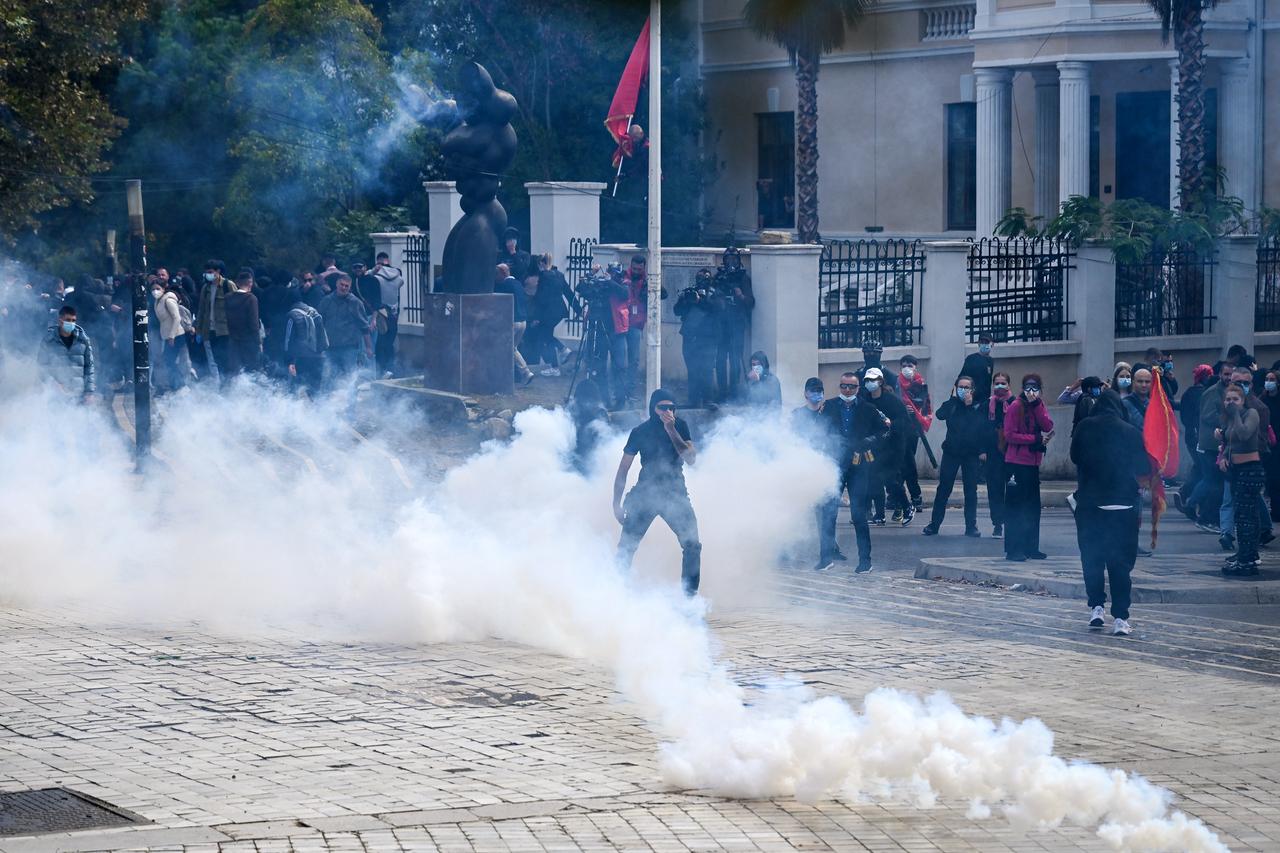Protesters stand amid tear gas fired by police during an anti-government demonstration in central Tirana on October 15, 2026. (AFP Photo)