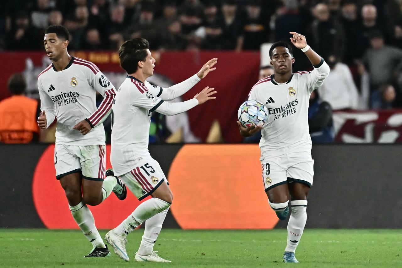 Real Madrid's Brazilian forward #09 Endrick celebrates with Real Madrid's Turkish midfielder #15 Arda Guler after scoring his team's third goal during the UEFA Champions League - 1st round day 2 football match between AS Roma and Real Madrid at the Olympic Stadium in Rome on October 14, 2026. (AFP Photo)
