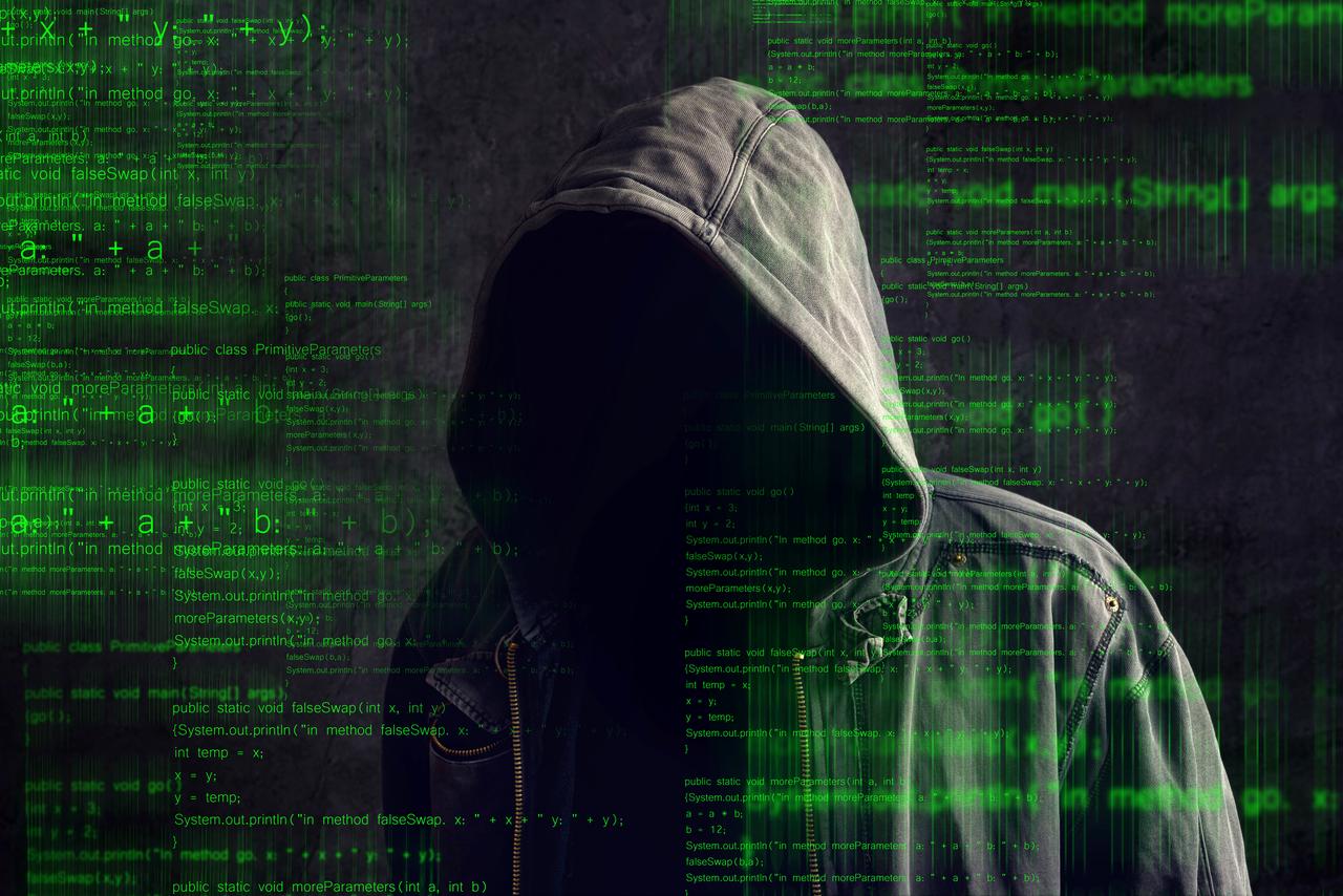 Photo shows faceless hooded anonymous computer hacker with programming code from monitor, accessed on Oct. 15, 2026. (Adobe Stock Photo)