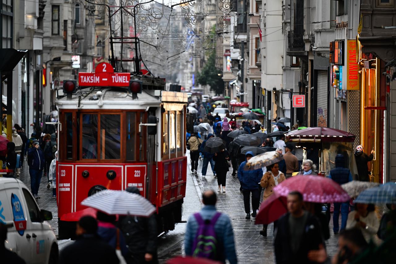 People use umbrellas to shield themselves from intermittent rainfall on Istiklal Street in Istanbul, Türkiye, on October 15, 2026. (AA Photo)