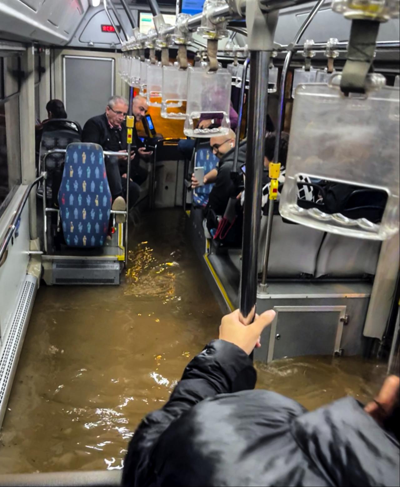 People seen in a flooded bus as severe torrential rainfall causes waterlogging and localized flash floods across streets and residential roads in the Kucukcekmece district of Istanbul, Türkiye, on October 14, 2026. (AA Photo)