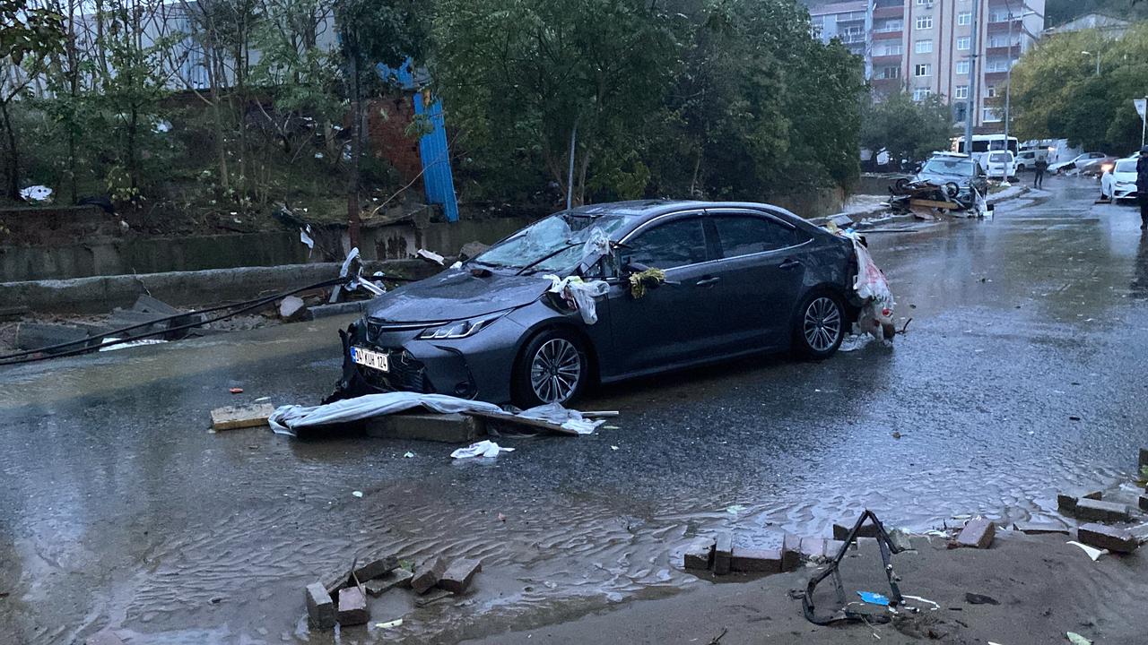 A car damaged by severe flooding is seen on a debris-covered street in Istanbul, Türkiye, following heavy rainfall that battered the city the previous day, October 15, 2026. (IHA Photo)