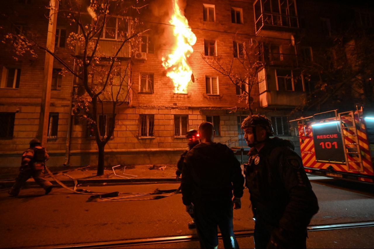 Ukrainian policemen and firefighters work at the site of a Russian drone strike at a multi-floor residential building in Kharkiv, late on October 12, 2026, amid the Russian invasion of Ukraine. (AFP Photo)