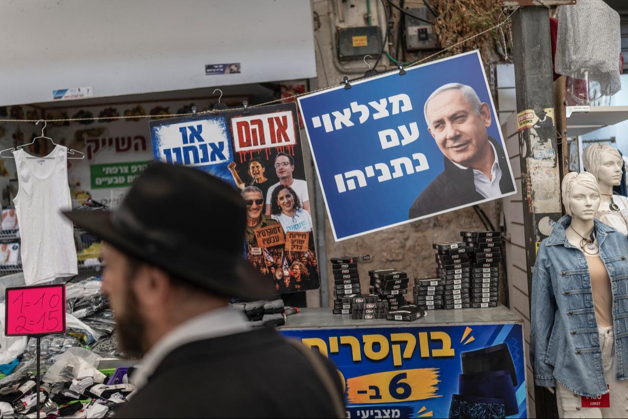 A man walks past a poster of Israel's Prime Minister Benjamin Netanyahu ahead of Israel's legislative election, at a market in Ramle on October 14, 2026. (AFP Photo)