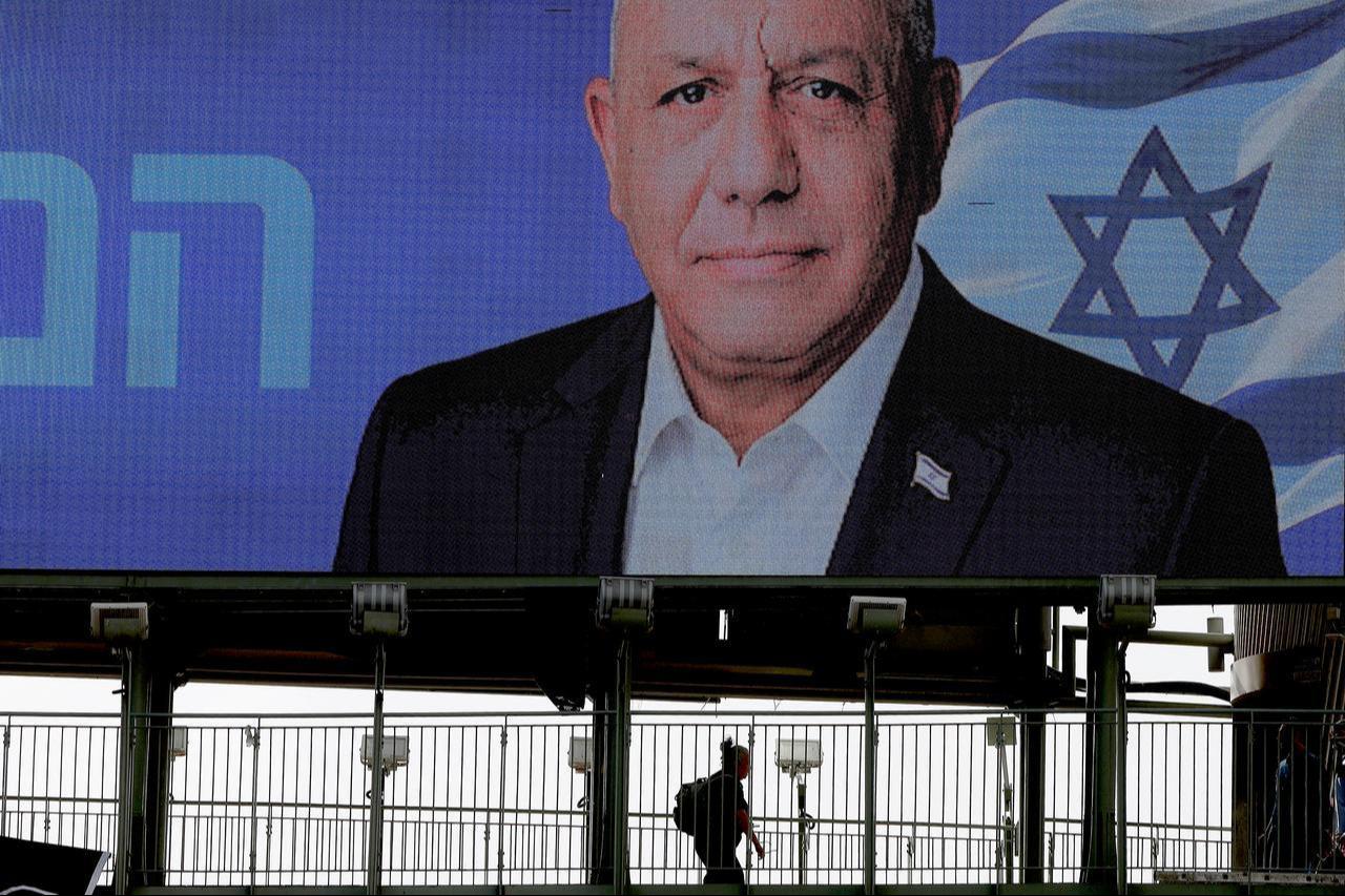 A person walks under an election billboard bearing a portrait of former military chief and leader of the centrist Yashar party, Gadi Eisenkot, with a message in Hebrew reading "Choosing the righteous way" in Ramat Gan, Oct. 15, 2026. (AFP Photo)