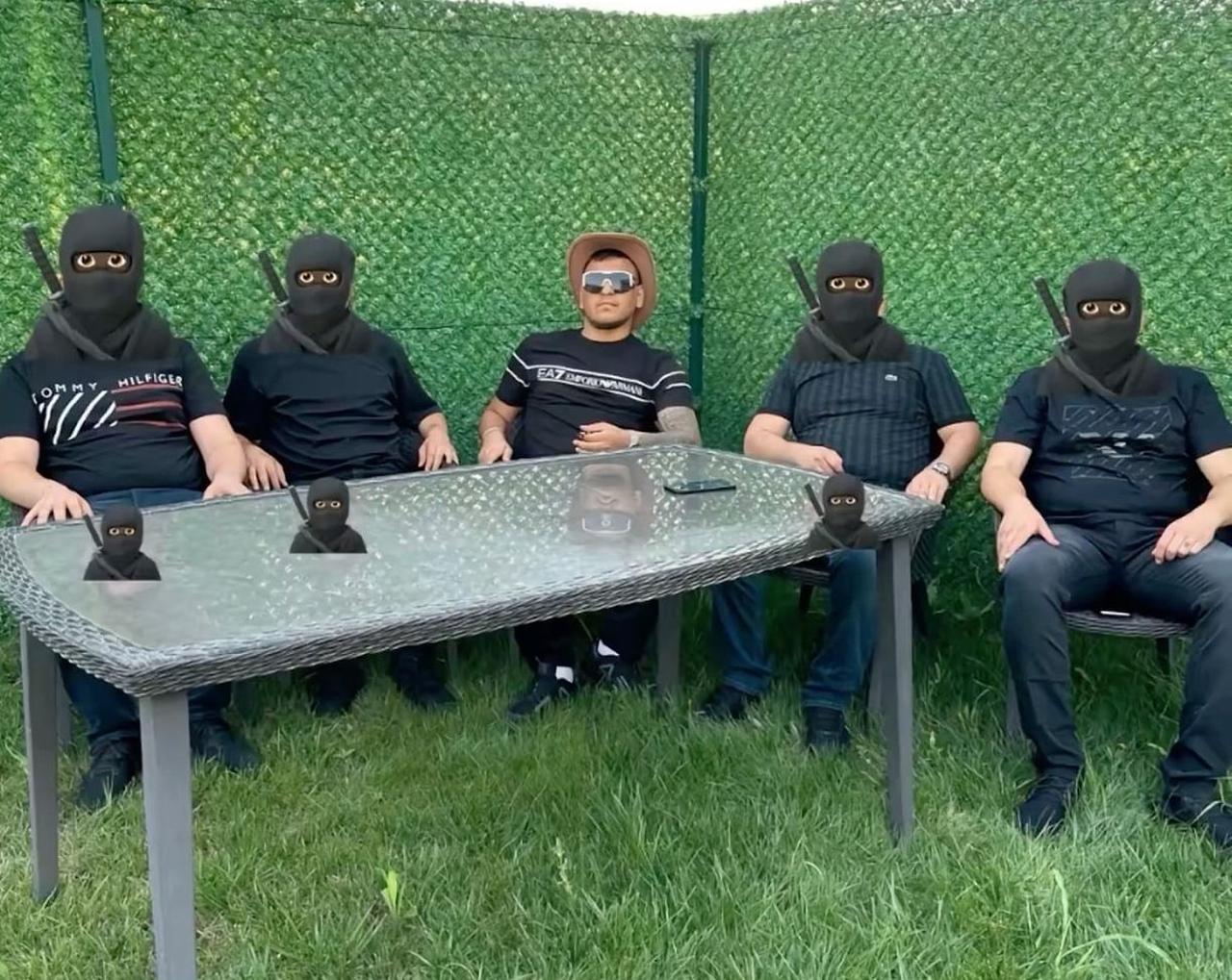 Masked members of the Turkish organized crime group known as the Daltons pose alongside alleged gang leader Beratcan Gokdemir. (Photo via X)