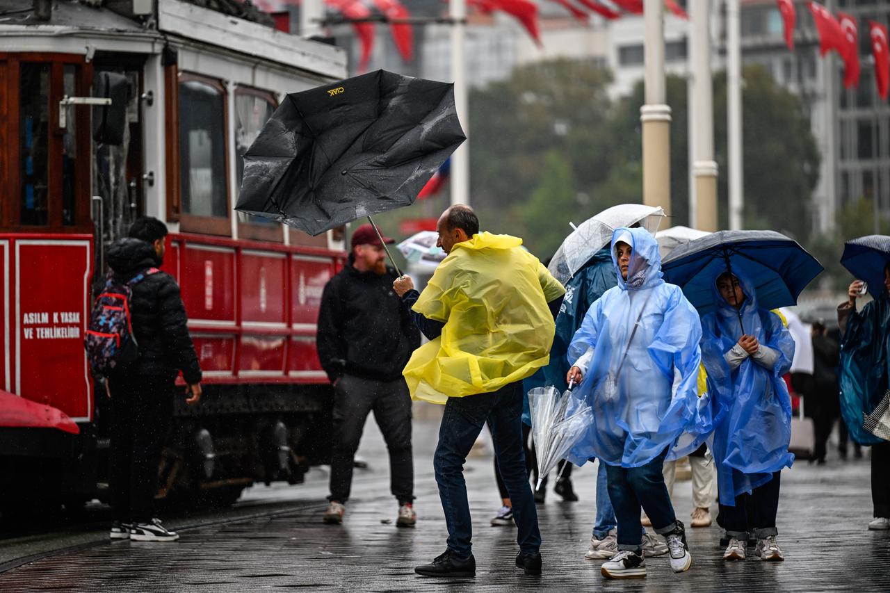 People use umbrellas to shield themselves from intermittent rainfall on Istiklal Street in Istanbul, Türkiye, on October 15, 2026. (AA Photo)