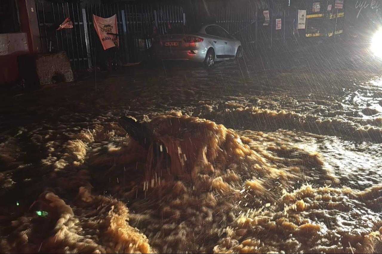 Muddy floodwater rushes across a street in Istanbul’s Ayazaga neighborhood as heavy rain falls on Oct. 14, 2026. (AA Photo)