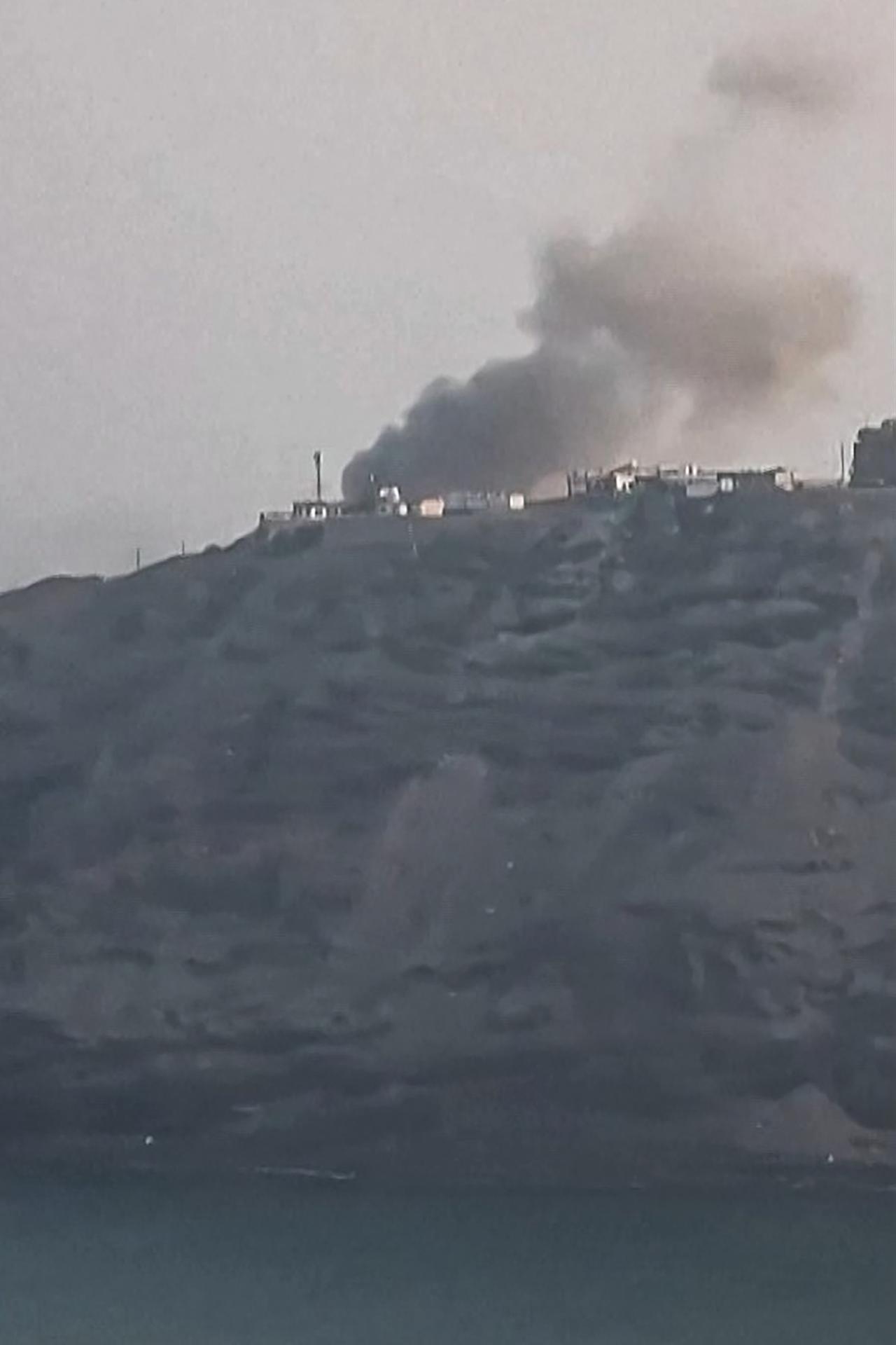 This screengrab taken from a UGC video posted on social media on October 15, 2026, shows smoke rising near the Maasheq lighthouse following a Houthi missile attack on the Yemeni government's presidential palace in the interim capital of Aden. (AFP Photo)