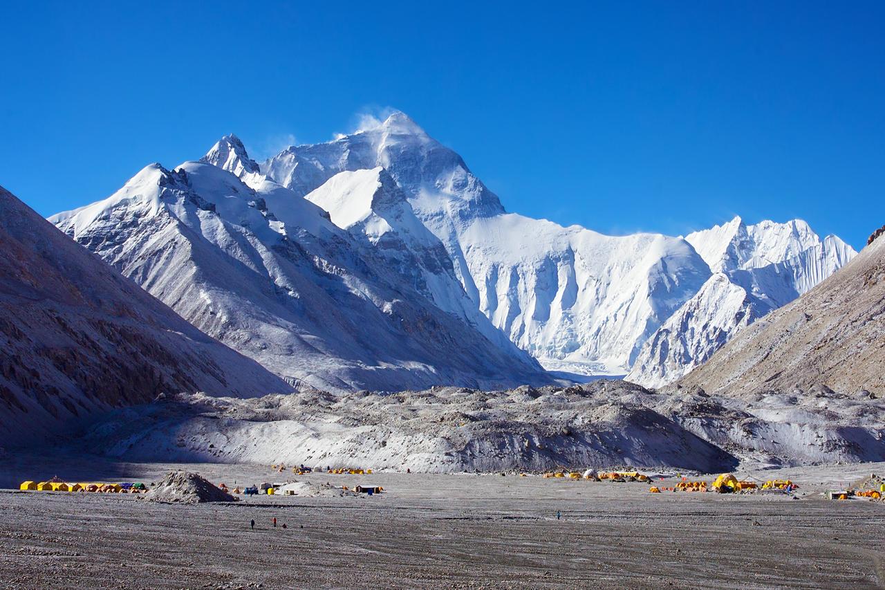 Snow-covered Mount Everest rises above a mountaineering base camp in the Himalayas. (Adobe Stock Photo)