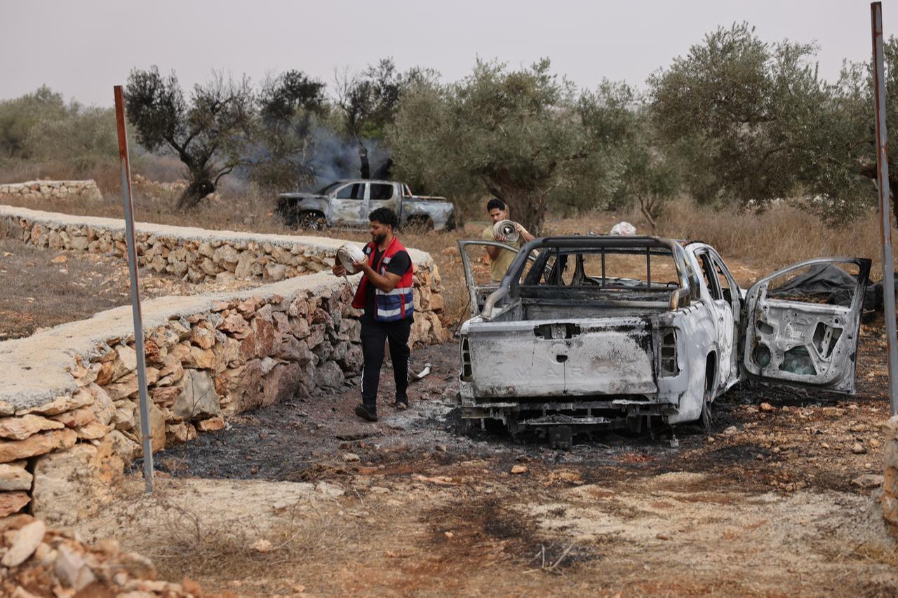 Palestinian volunteers pack up hoses used to put out a fire that illegal Israeli settlers reportedly set to an olive tree and Palestinian-owned vehicles near Turmus Ayya, north of Ramallah, in the occupied West Bank, Oct. 16, 2026. (AFP Photo)