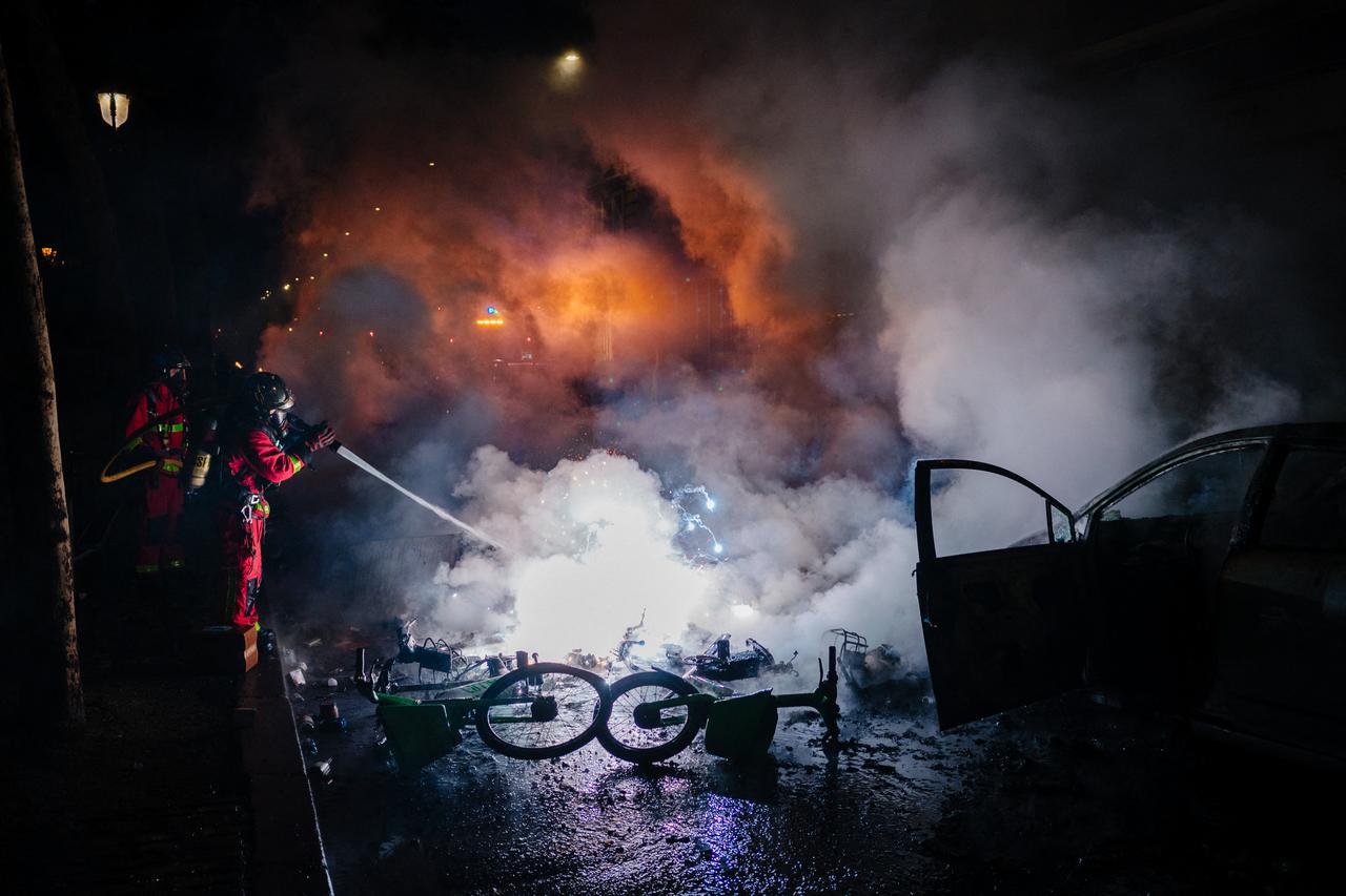 Firefighters extinguish a burning car along the Canal Saint-Martin during ongoing protest action against the "high cost of living", in Paris on October 17, 2026. (AFP Photo)