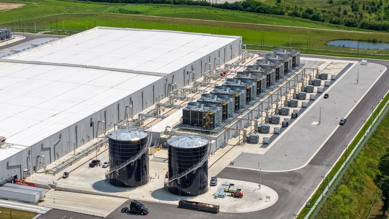 An aerial view shows cooling towers, water storage tanks and industrial infrastructure outside a large data center facility. (Adobe Stock Photo)