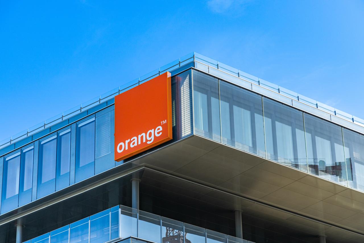 The Orange logo is displayed on the telecommunications company's headquarters building in Issy-les-Moulineaux, near Paris, France. (Adobe Stock Photo)