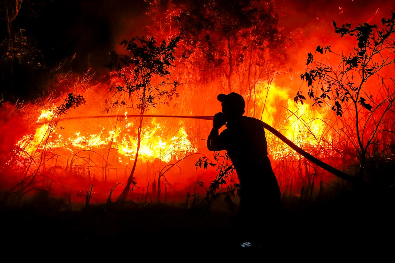 A firefighter from the Regional Disaster Management Agency battles a forest fire at Sungai Rambutan village in Ogan Ilir, South Sumatra on Sept. 11, 2026. (AFP Photo)