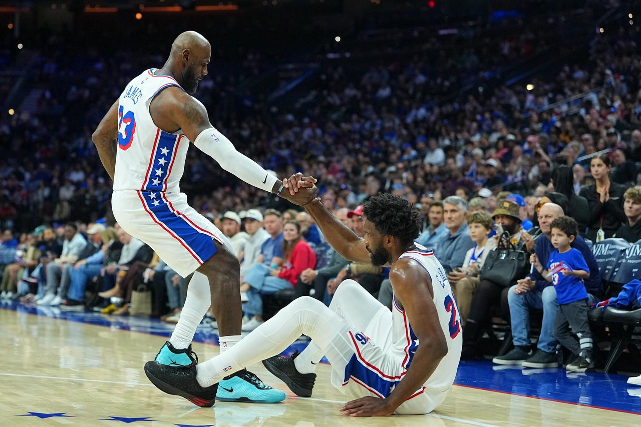 Philadelphia 76ers' LeBron James (23) helps teammate Joel Embiid (21) off the court during an NBA game against the Boston Celtics in Philadelphia, Pennsylvania, U.S., Oct. 17, 2026. (AFP Photo)