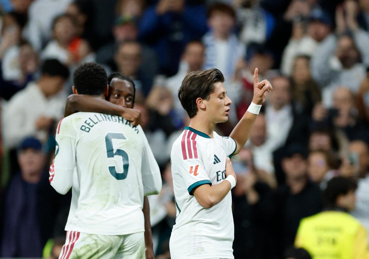 Real Madrid's Turkish midfielder #15 Arda Guler (R) celebrates scoring his team's first goal with teammates during the Spanish league football match between Real Madrid CF and Sevilla FC at the Santiago Bernabeu stadium in Madrid on October 18, 2026. (AFP Photo)
